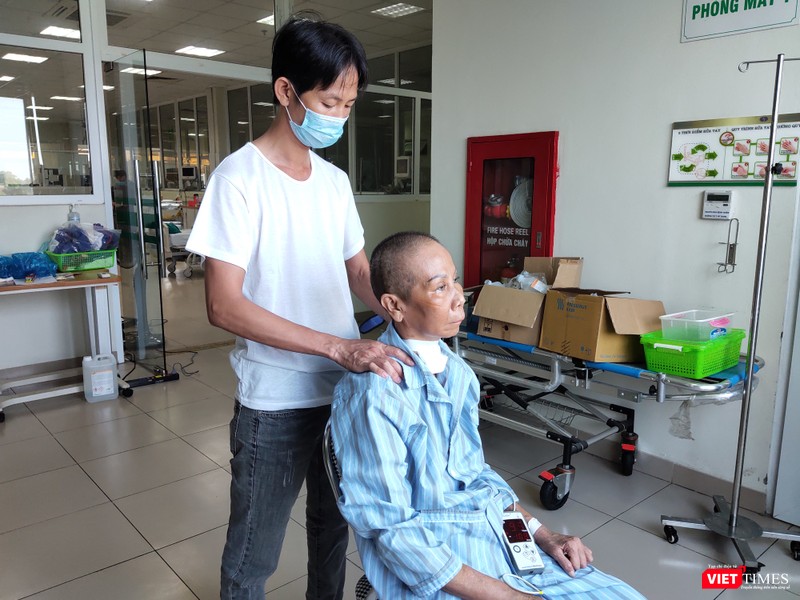 Con trai bệnh nhân 20 chăm sóc cho mẹ. Ảnh: Minh Thúy