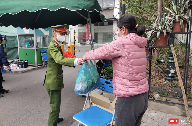 Người dân gửi đồ ăn cho người thân ở bên trong khu chung cư bị phong toả (Ảnh - Minh Thuý) 