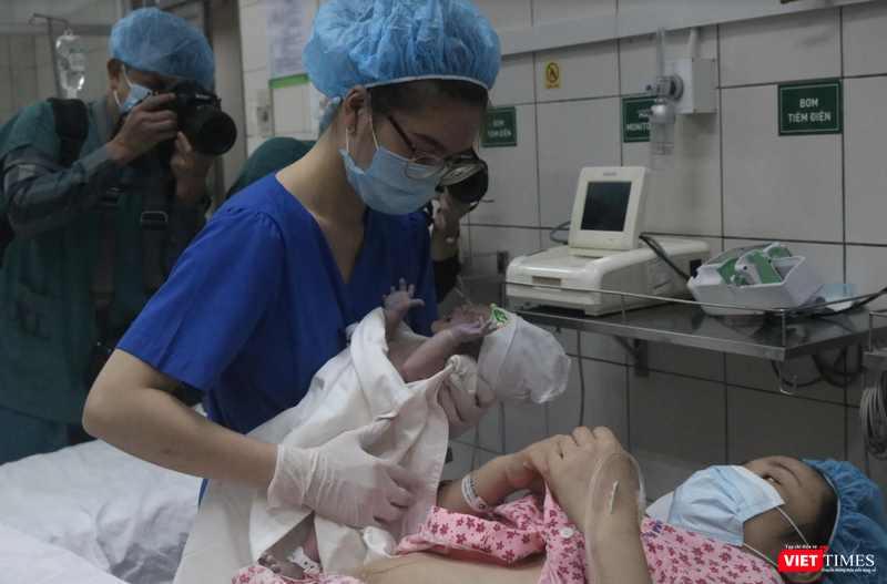 Y tá đưa bé đi cân