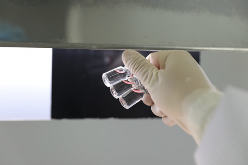 Vaccine sau đó được chuyển đến bàn soi, nhằm kiểm tra dị vật trong lọ Vaccine sau đó được chuyển đến bàn soi, nhằm kiểm tra dị vật trong lọ