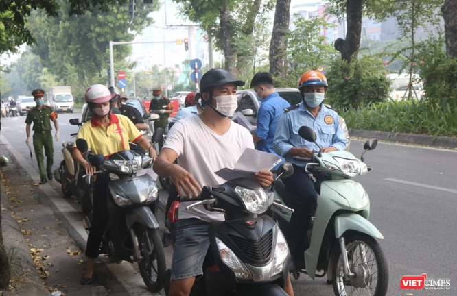 Người dân xếp hàng chờ kiểm tra giấy đi đường (Ảnh - Minh Thuý) 