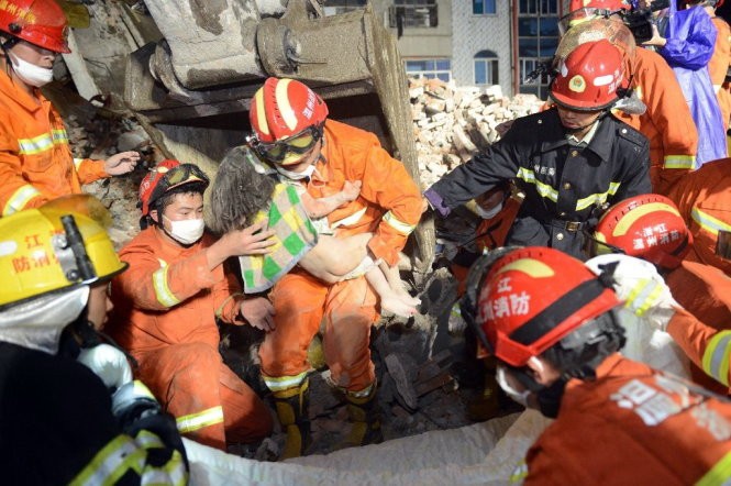 Bé Wu đã được cứu sống nhờ vào sự che chở của người cha - Ảnh: AFP