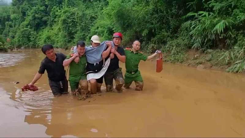 Mưa lớn gây ngập nhiều tuyến đường xã Hữu Kiệm (huyện Kỳ Sơn cũ) công an phải dùng canô, sau đó đi bộ dìu sản phụ vượt bùn lầy đến trạm y tế. Anh 1.jpg