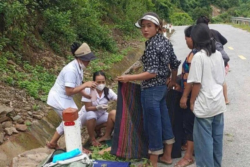 Hai nữ y sĩ đỡ đẻ thành công cho sản phụ ngay bên đường. Ảnh: Vi Ngọc Mai. Anh 2.jpg