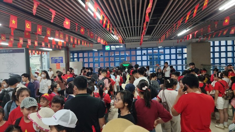 Không khí tại các ga không khác gì một ngày hội. Dòng người xếp hàng mua vé kéo dài hàng trăm mét. Các tiểu thương tranh thủ bày bán cờ, băng rôn, biến khu vực ga thành một điểm nhấn rực rỡ sắc đỏ sao vàng. 20250824_135619 (1).jpg