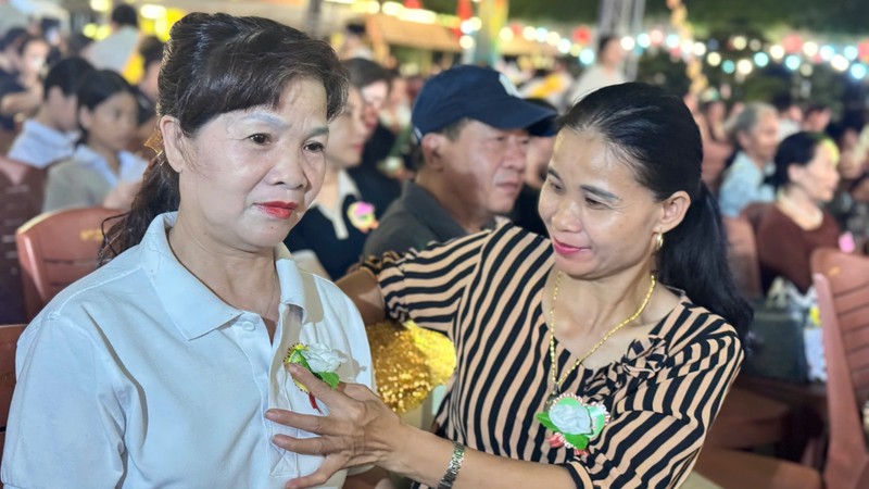 Nghi thức bông hồng cài áo, mang ý nghĩa sâu sắc. Những ai còn cha mẹ sẽ cài lên ngực bông hồng đỏ thắm. Những ai đã mất cha hoặc mẹ sẽ cài bông hồng trắng. Ảnh: Q.A. Anh 1.jpeg