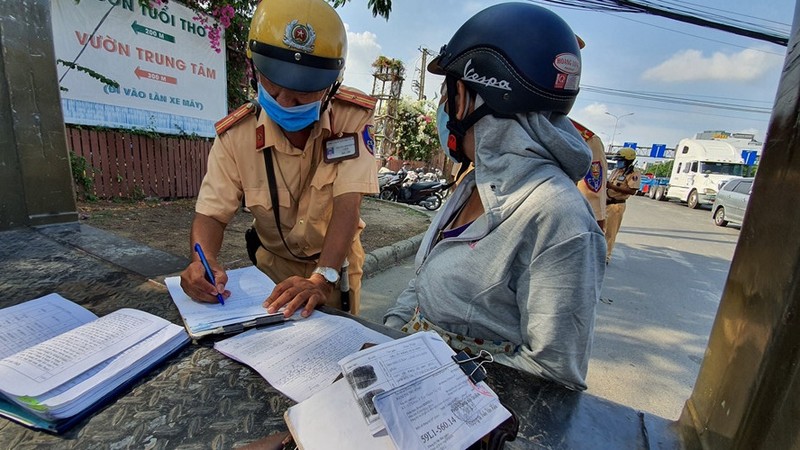 Một người phụ nữ bị CSGT phạt vì mang giấy tờ xe photo dù có chứng thực. Ảnh: Thanh Niên