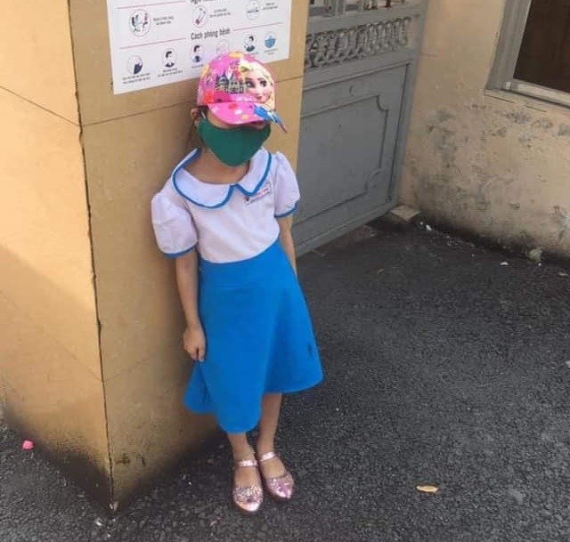 Một học sinh lớp 1 đứng ngoài nắng vì đi học sớm. Ảnh: Internet