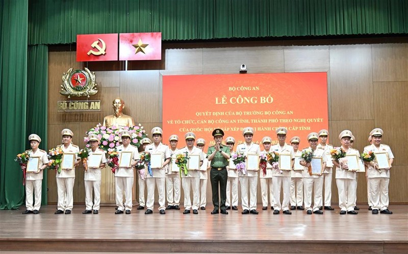 Bộ trưởng Lương Tam Quang trao quyết định và tặng hoa chúc mừng 23 giám đốc công an địa phương sau sáp nhập. Ảnh: Bộ Công an 28-6 BCA2.jpg