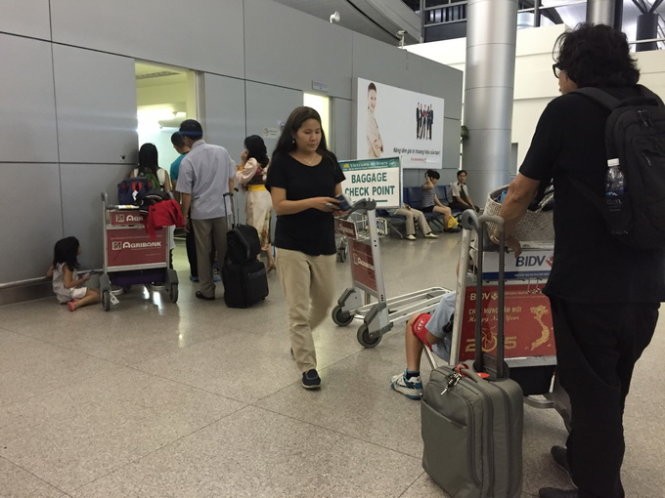 Hành khách đi nước ngoài chờ kiểm tra hành lý ký gửi tại phòng soi của hải quan sân bay quốc tế Tân Sơn Nhất chiều 7-4