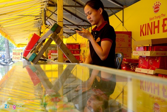 Không có khách, nhân viên giết thời gian bằngsmartphone. Lý giải nguyên nhânế khách, một chủ quầy trên đường 3/2cho biết, năm nay, thời tiết Sài Gòn mưa, ngập liên tục, nhất là vào giờ caođiểm nênkhách ngại vào mua. Bên cạnh đó, các mốiđặt hàng lớn để tặng, biếu giảmđáng kể. Nhiều quầy mở bán sớm, khách đã muanên hiện tại bị bão hoà vềsức tiêu thụ.