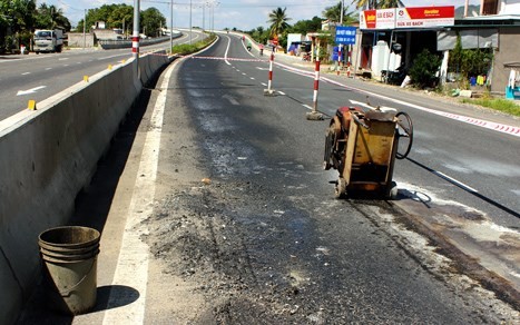 Mặt đường trên quốc lộ 1A, huyện Cam Lâm (Khánh Hòa) bong tróc, đơn vị thi công căng dây khắc phục (Ảnh:VnExpress)