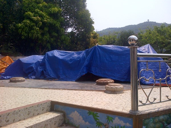 Gỗ sau khi tháo dỡ được tập kết lại và che bạt kín. Gỗ sau khi tháo dỡ được tập kết lại và che bạt kín.