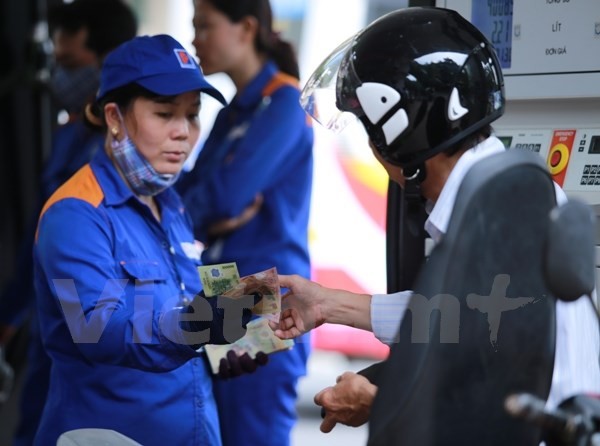 Nhân viên Petrolimex đang bơm xăng cho khách hàng (Ảnh: Đức Duy/Vietnam+)