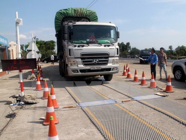 Lực lượng chức năng tiến hành kiểm soát tải trọng xe. (Ảnh: Sỹ Tuyên/TTXVN)