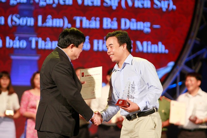 Phóng viên Thái Bá Dũng thay mặt nhóm tác giả báoTuổi Trẻnhận giải C với loạt bài Những câu chuyện bên đường bên giới - Ảnh: NAM TRẦN