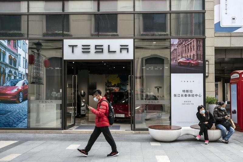 Một người mua sắm đi ngang qua một phòng trưng bày Tesla ở Thượng Hải vào tháng 3 (Ảnh: Bloomberg)