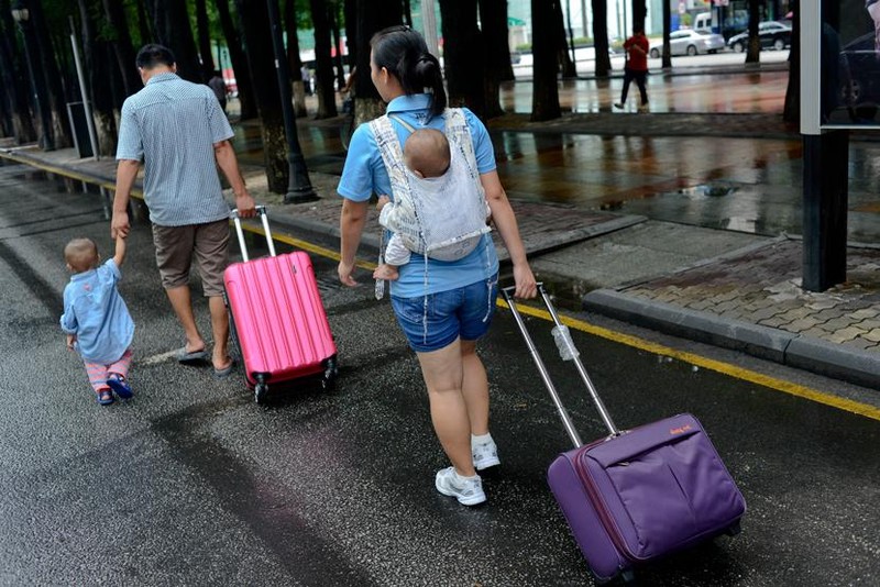 Một cặp vợ chồng đi dạo với con ở Đông Quan, tỉnh Quảng Đông, 2013. Ảnh: People Visual