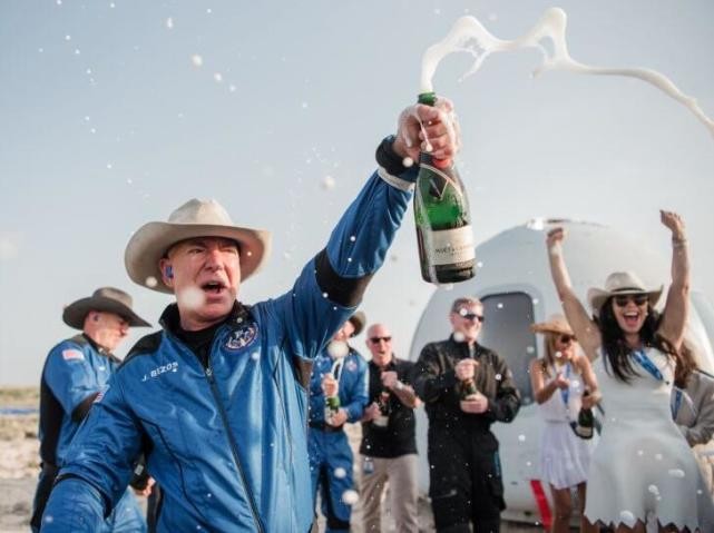 Bezos mở rượu sâm panh để ăn mừng thành công của chuyến bay vũ trụ đầu tiên