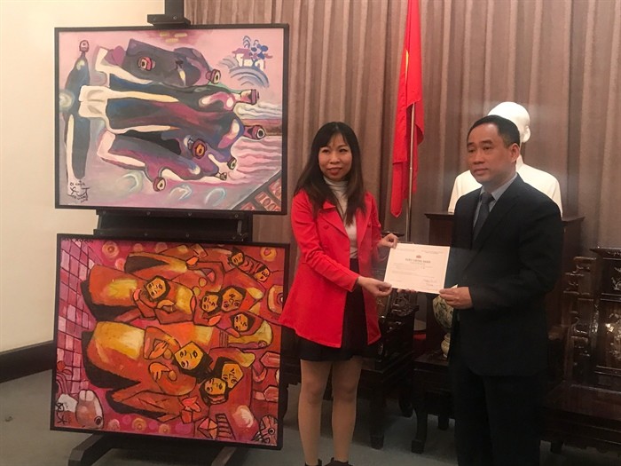 Ông Nguyễn Anh Minh trao giấy chứng nhận tiếp nhận tác phẩm cho đại diện gia đình họa sĩ