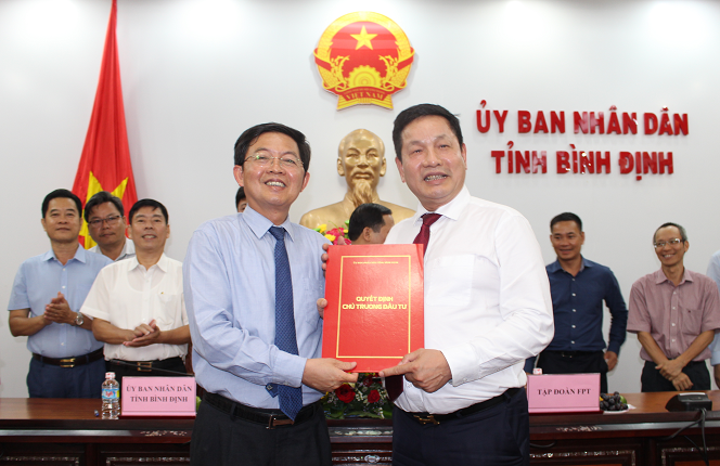 Chủ tịch UBND tỉnh Hồ Quốc Dũng trao quyết định chủ trương đầu tư cho đại diện FPT - ông Trương Gia Bình (Ảnh: binhdinh.gov.vn)