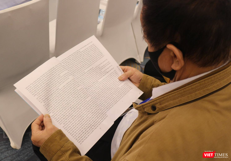 Một cổ đông lớn tuổi chăm chú tìm hiểu chương trình nghị sự tại AGM 2023 của SHB