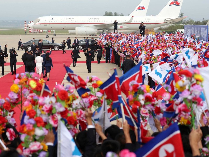 Những người ra đón mang theo hoa, quốc kỳ Triều Tiên và cờ Bán đảo