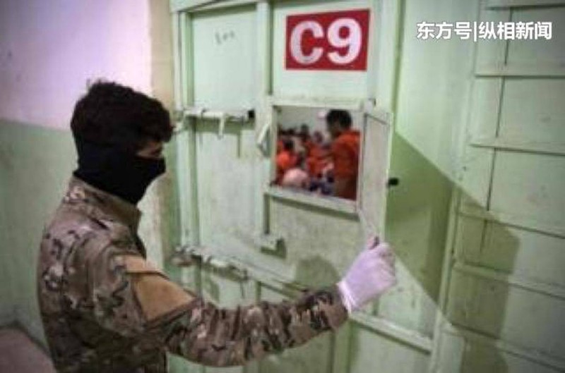 Một binh sỹ người Kurd kiểm tra tù binh IS bị giam giữ trong trại giam.