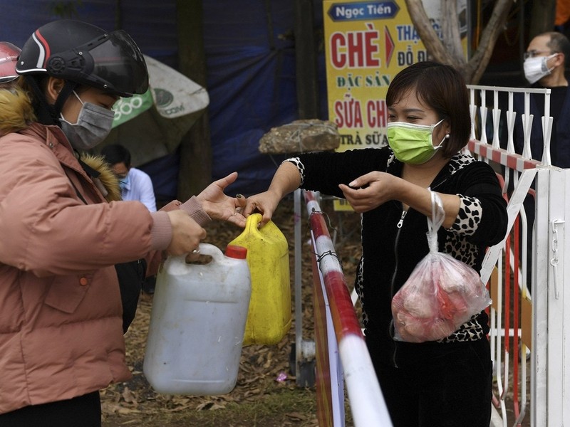 Các nhân viên cơ sở đảm nhiệm việc cung cấp nhu yếu phẩm sinh hoạt do người dân trong khu vực cách ly (Ảnh: AFP).