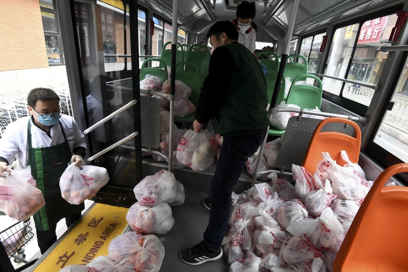 Nhân viên siêu thị sử dụng xe bus mang hàng hóa tới tận các khu dân cư (Ảnh: Reuters)