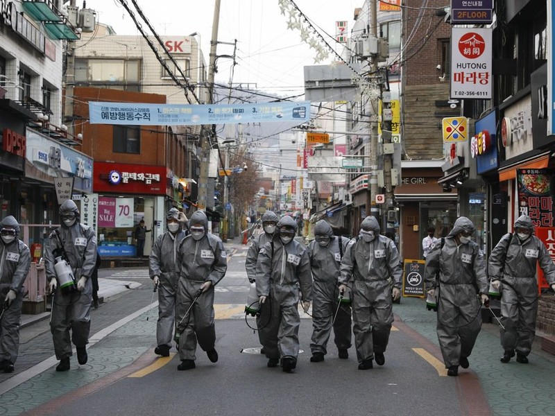 Các nhân viên phòng dịch quân đội Hàn Quốc phun thuốc khử trùng trên đường phố (Ảnh: Tân Hoa xã).