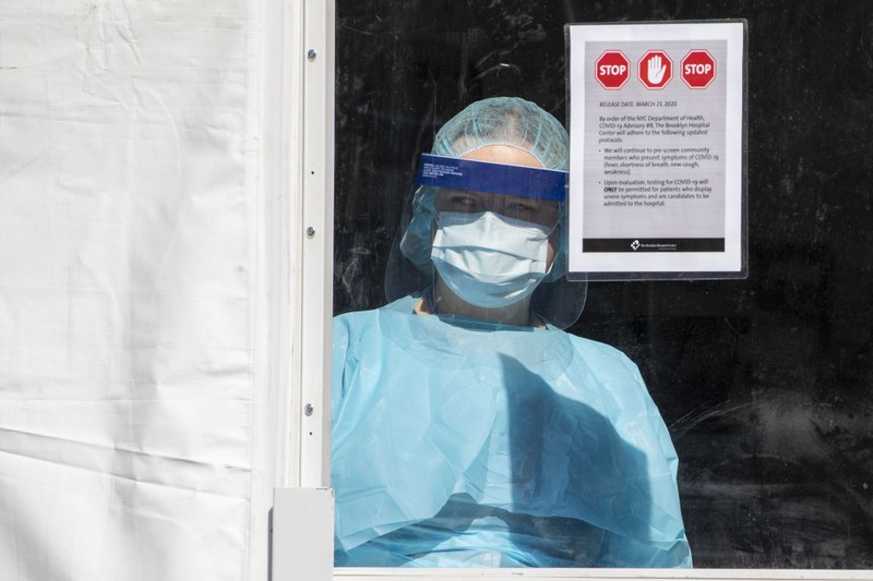 Số bệnh nhân quá nhiều, các bác sĩ phải căng mình làm việc. Một bác sĩ trong khu cách ly (Ảnh: AP).