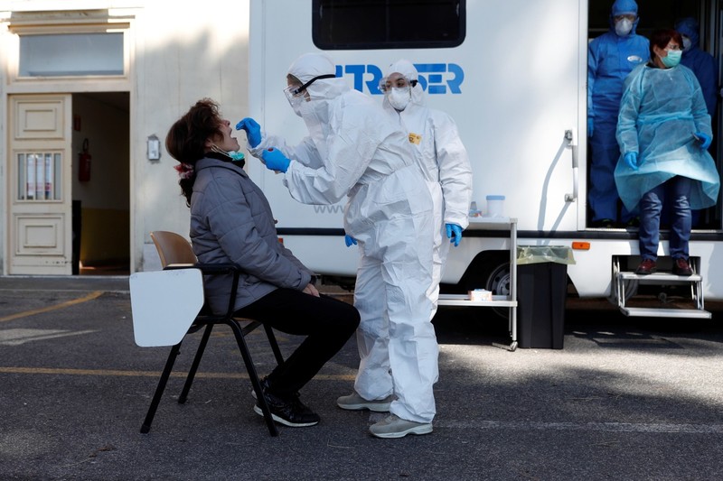 Ngày 1/4, giờ địa phương, tại Rome, một nhân viên y tế mặc đồ bảo hộ đang lấy mẫu của một phụ nữ bị nghi nhiễm bệnh để xét nghiệm virus Corona mới (Ảnh: Reuters). Ngày 1/4, giờ địa phương, tại Rome, một nhân viên y tế mặc đồ bảo hộ đang lấy mẫu của một phụ nữ bị nghi nhiễm bệnh để xét nghiệm virus Corona mới (Ảnh: Reuters).