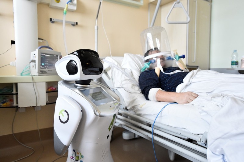 Một y tá robot đang giúp điều trị một bệnh nhân nặng bị viêm phổi do virus Corona mới (Ảnh: Reuters). Một y tá robot đang giúp điều trị một bệnh nhân nặng bị viêm phổi do virus Corona mới (Ảnh: Reuters).