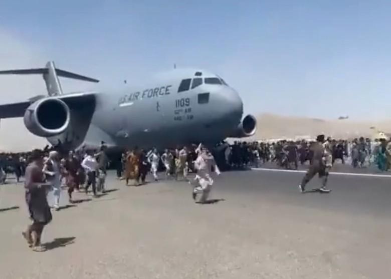 Cảnh người dân bám và chạy theo khi chiếc C-17 cất cánh (Ảnh: Đông Phương).