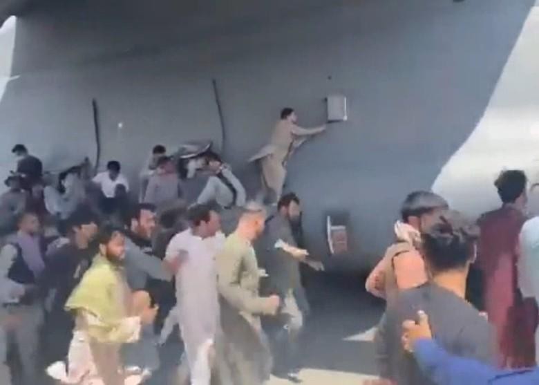 Nhiều người bám vào mọi chỗ có thể bám được phía ngoài chiếc C-17 (Ảnh: Đông Phương).