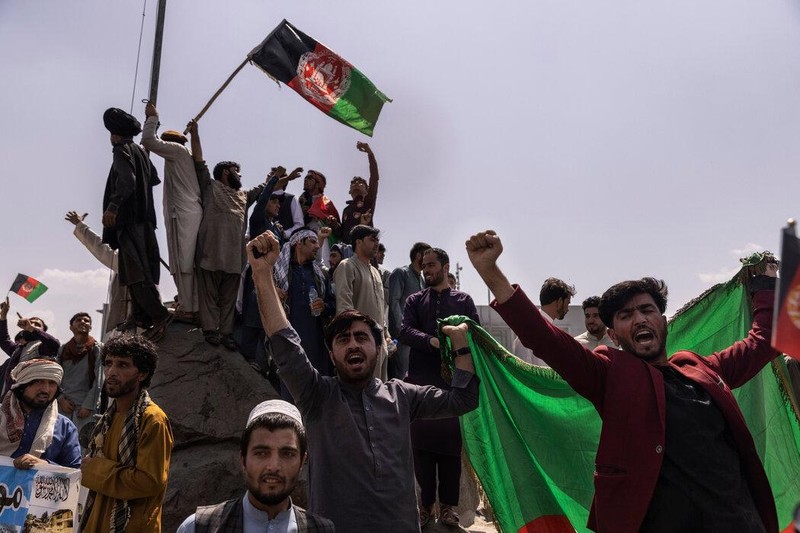 Những người biểu tình vẫy cờ của chính phủ Afghanistan bị lật đổ tại Quảng trường Pashtostan ở Kabul hôm 19/8 (Ảnh: The New York Times).