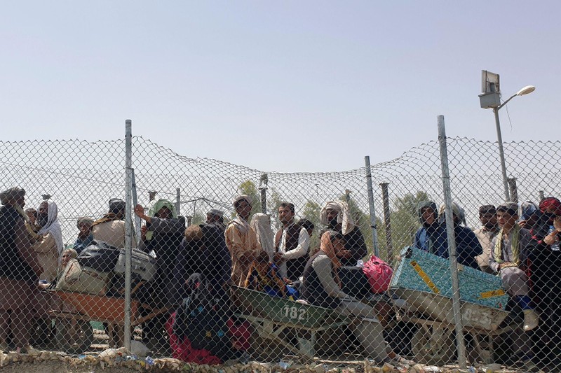 Người Afghanistan tị nạn bị chặn lại bên kia hàng rào biên giới với Pakistan (Ảnh: Reuters).