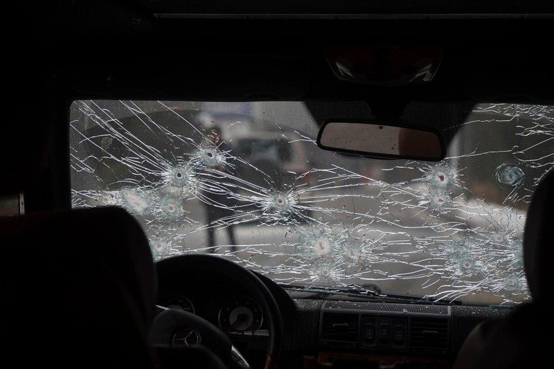 Một xe cảnh sát bị những người bạo loạn bắn trực diện với những vết đạn trên kính phía trước (Ảnh: AP).