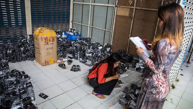 Nhân viên đang kiểm kê phụ kiện điện thoại di động tại một cửa hàng ở Yangon
ẢNH: BLOOMBERG