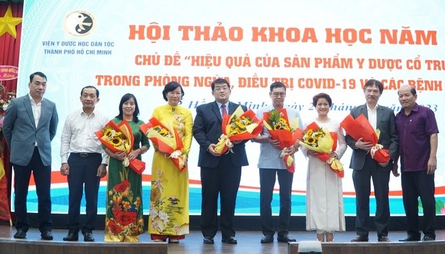 Các đại biểu tặng hoa chúc mừng các nhà nghiên cứu ứng dụng thuốc y học cổ truyền vào thực tế