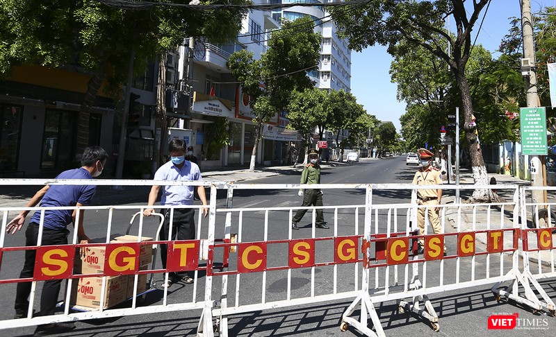 Người bên trong khu cách ly ra lấy hàng sau hệ thống rào chắn