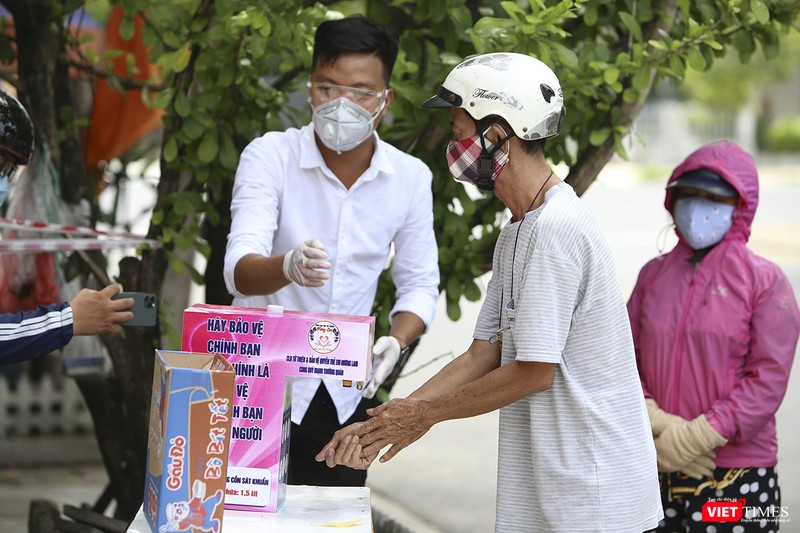 Người dân thực hiện rửa tay sát khuẩn trước khi mua hàng