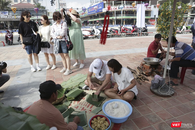 Du khách trải nghiệm gói bánh chưng