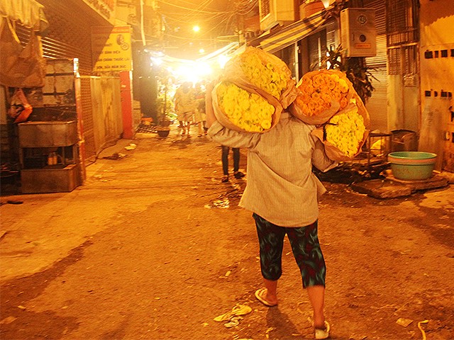 Một mình chị cân cả thế giới hoa trên vai khi hàng vừa xuống xe.