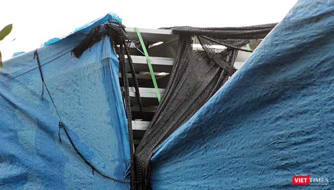 Sau nhiều năm, trải qua mưa nắng, các tấm bạt đã chịu để lộ sản phẩm được che kín bên trong.
