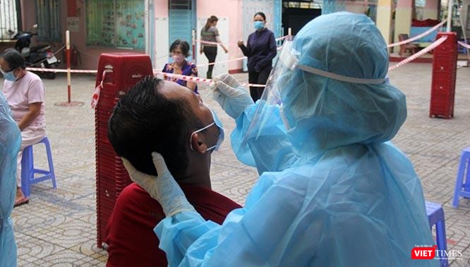 Thao tác của các kỹ thuật viên khi lấy mẫu cho người dân ở TP.HCM. Có người cười xoà: "Chỉ ngứa xíu thôi mà". Ảnh: GVT.