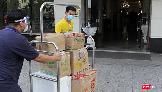 Trần Đức Phong (áo vàng) và Bùi Văn Nghĩa (áo xanh đen), một người là bác sĩ tới từ Hà Nội, một người là doanh nghiệp ở TP.HCM, đang hì hụi đẩy xe quà là tấm lòng của bà con Sài Gòn gửi tới các y, bác sĩ của đoàn Bệnh viện Bạch Mai tăng cường cho thành phố. Ảnh: GVT.