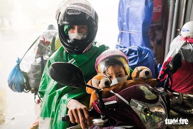 Người dân lặn lội mưa gió vượt hàng ngàn km bất chấp nguy hiểm để về quê. Ảnh: Tuổi trẻ.