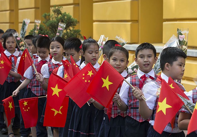 Các thiếu nhi vẫy cờ chào mừng tại lễ đón tiếp - Ảnh: Việt Dũng